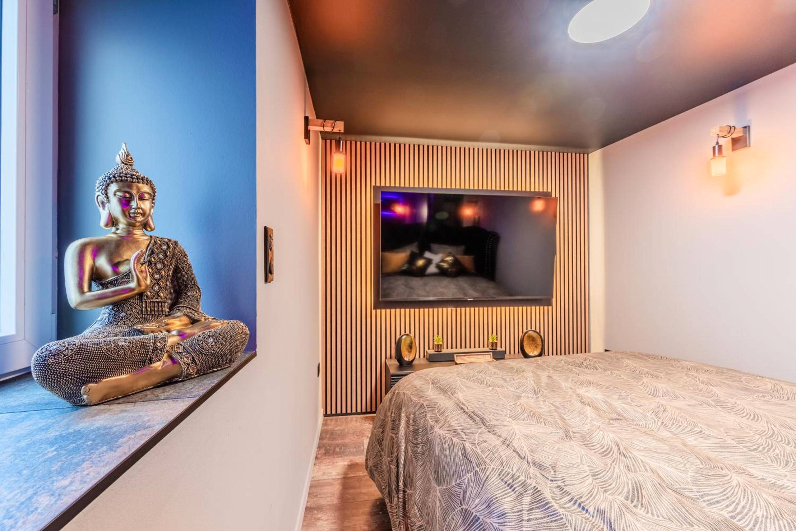 Chambre avec lit double, TV et statue de Bouddha - Suite romantique & Spa privatif pour 2 en Alsace