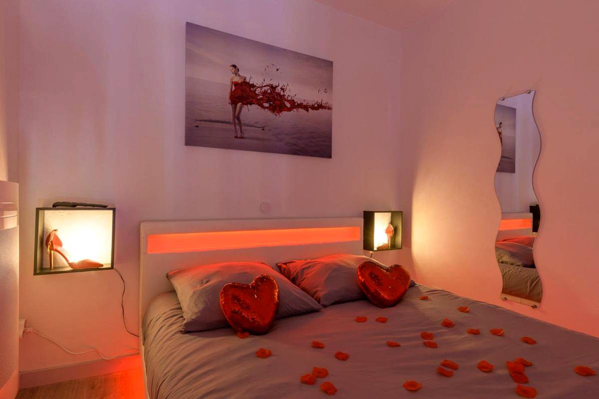 Lit double avec pétales et coussins cœurs - Love Room - Suite romantique avec spa privatif