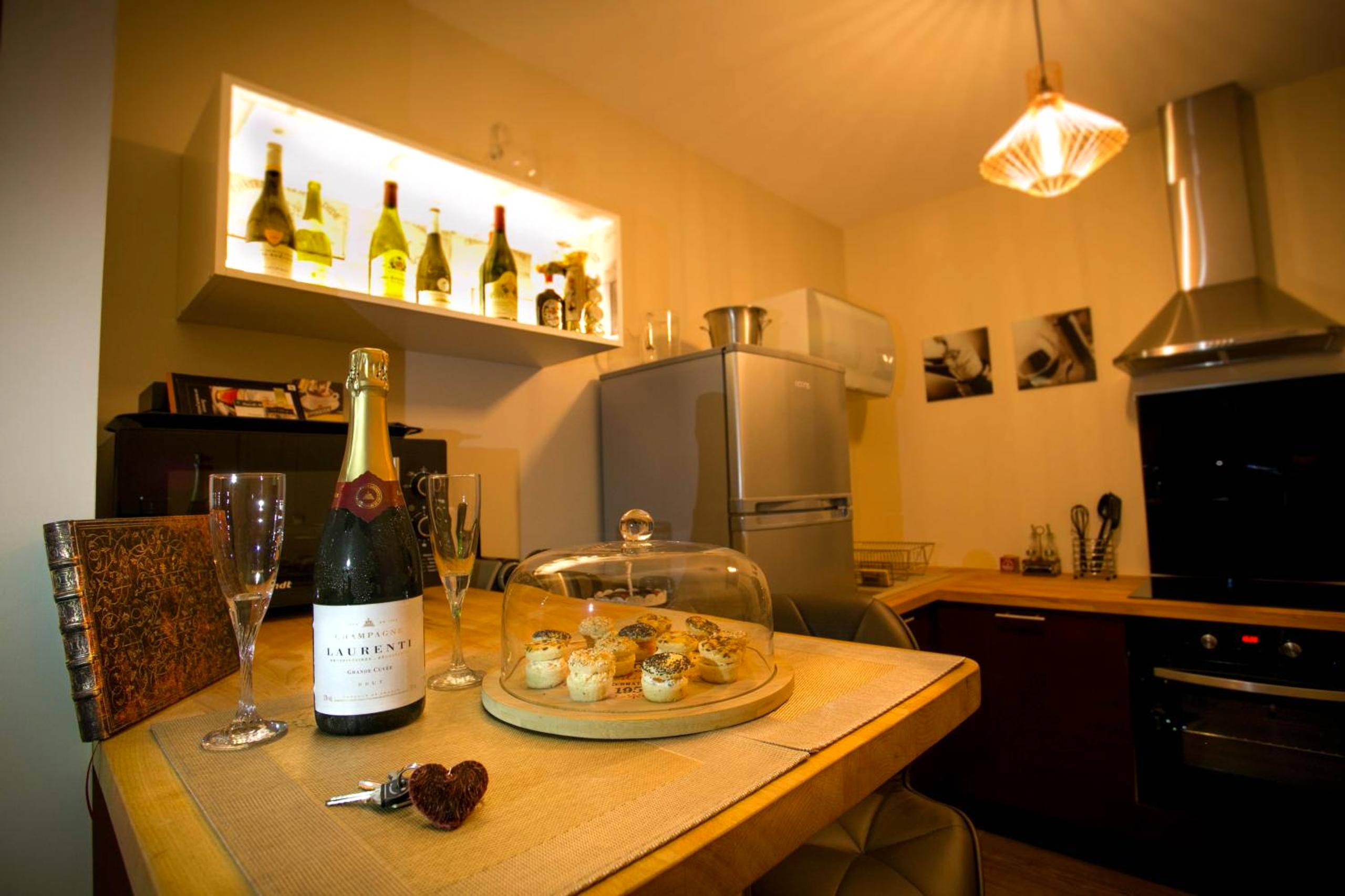 Bouteille de champagne et mignardises en cuisine - Suite Romantique & Spa