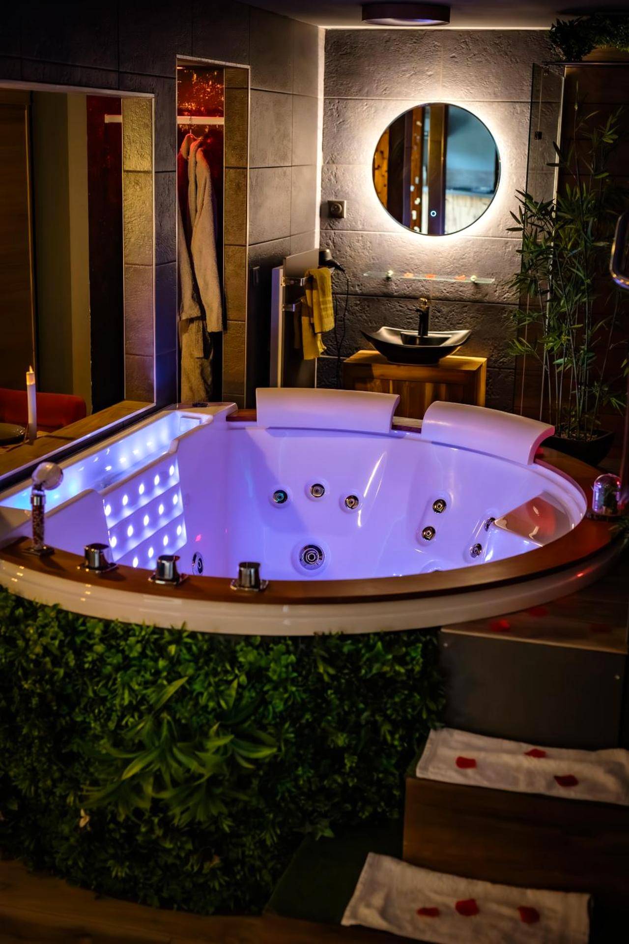 Jacuzzi rond avec éclairage LED et mur végétal - Love Room Saint - Blimont - Suite Romantique avec Spa Privatif Sauna &...