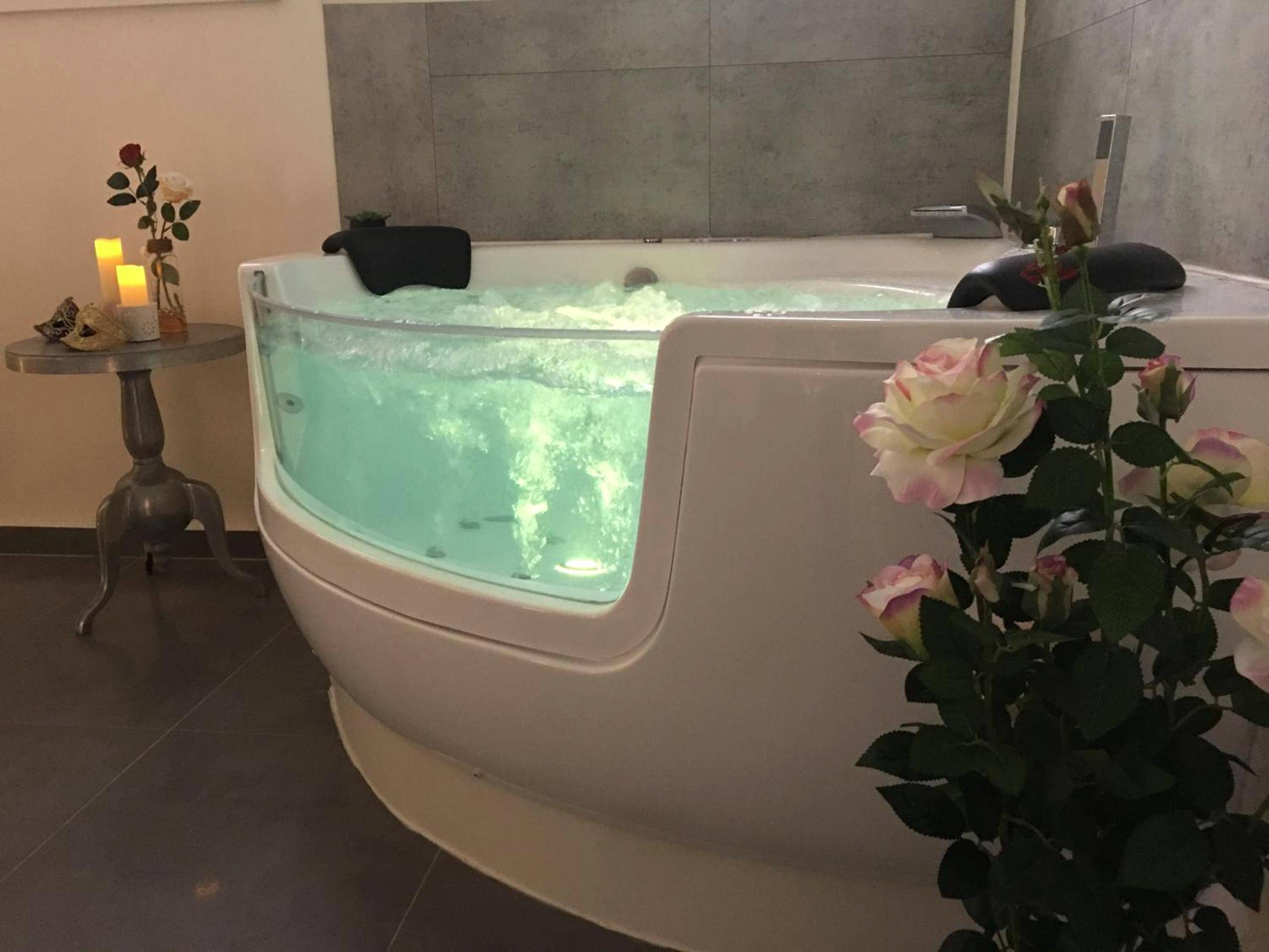 Jacuzzi privatif avec paroi vitrée et roses - Suite & SPA