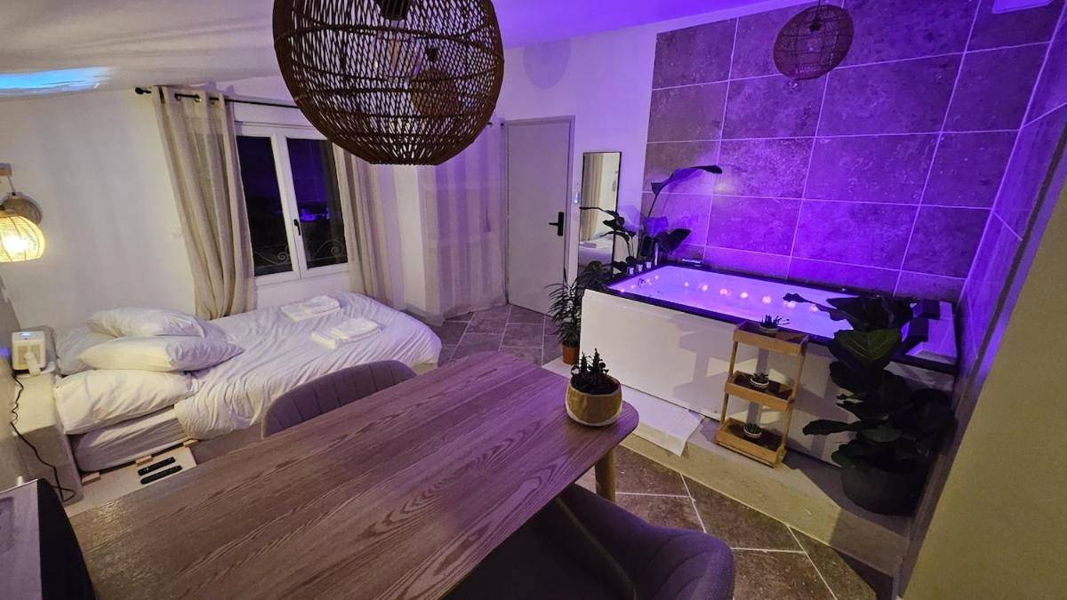 Espace de vie avec lit double et jacuzzi - La Suite Tilleul