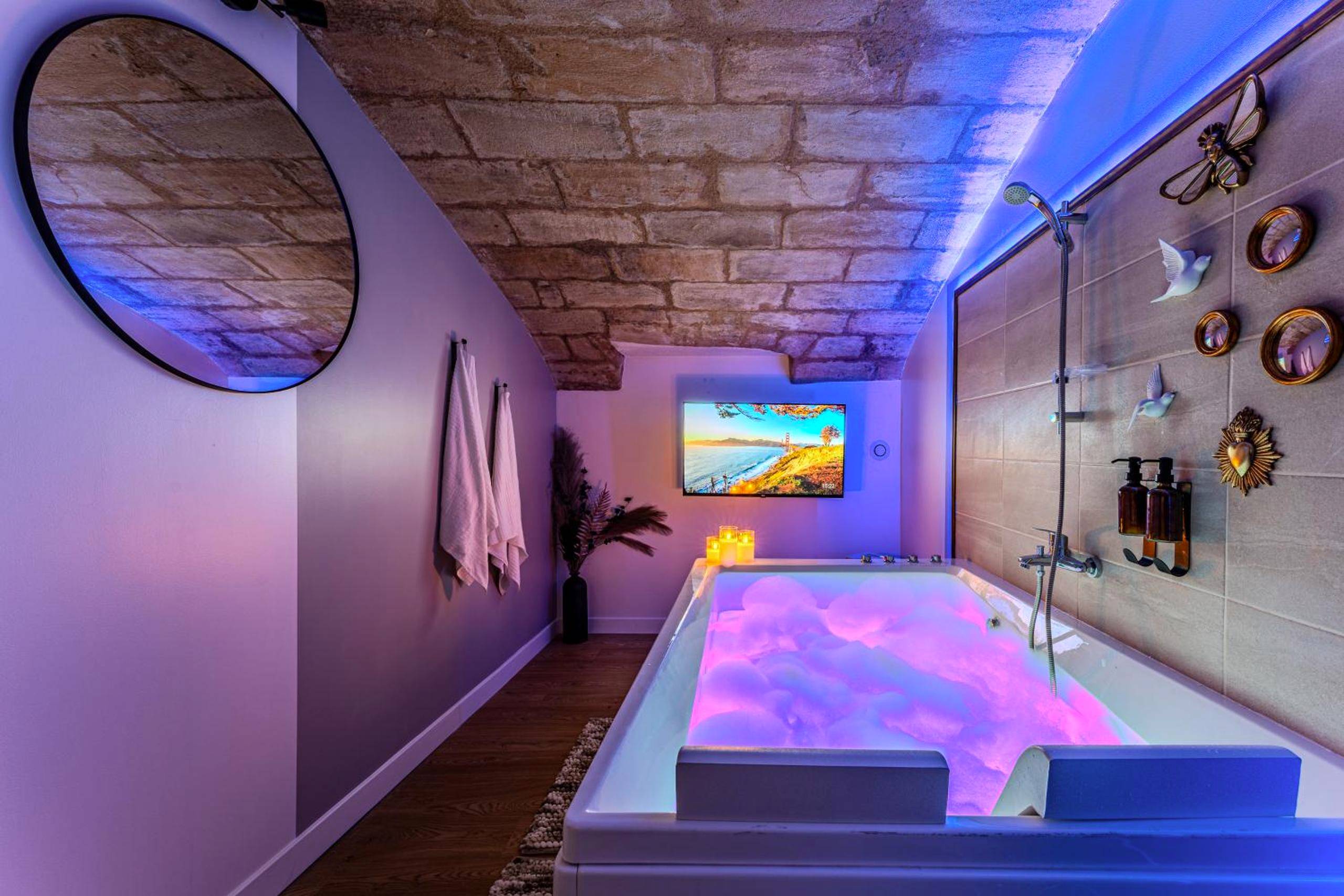 Jacuzzi privatif avec éclairage LED rose - Suite d'Exception sous Voûtes avec Spa & Cinéma