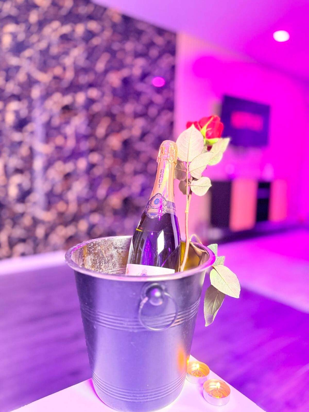 Bouteille de champagne et rose dans un seau - Les Suites Bisous Metz - Jacuzzi & Private Sauna