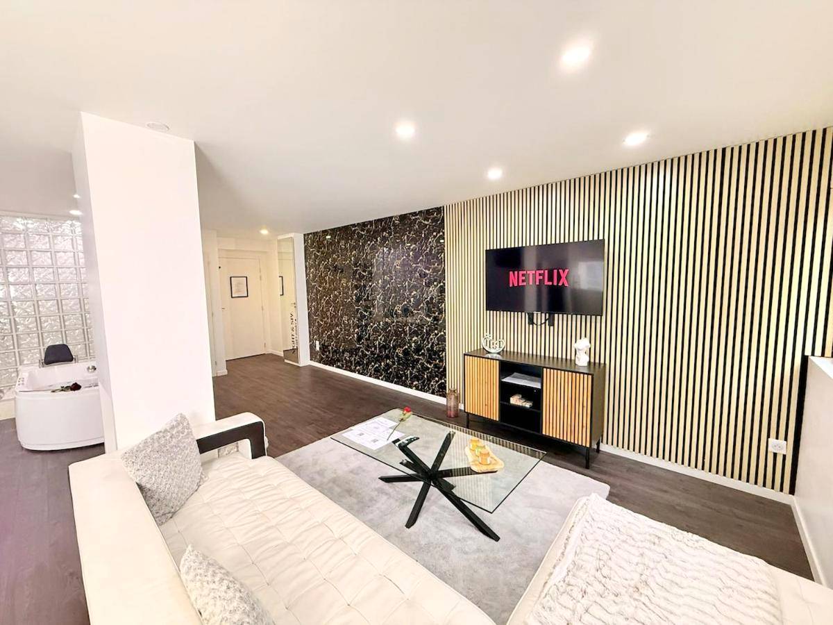 Salon moderne avec canapé et écran plat - Les Suites Bisous Metz - Jacuzzi & Private Sauna