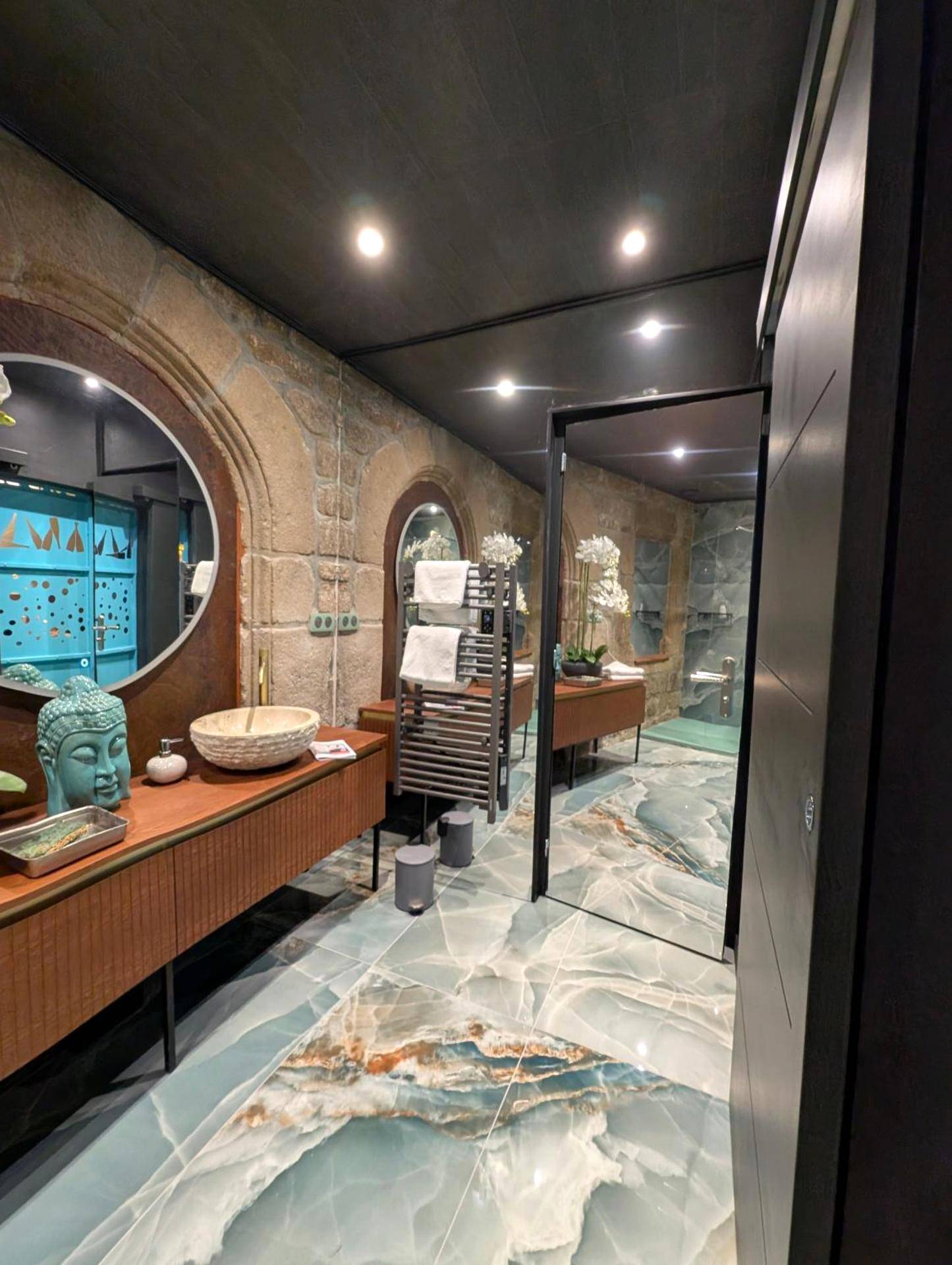 Salle de bain avec vasque en pierre et miroir - Les suites du Bouddha Bleu