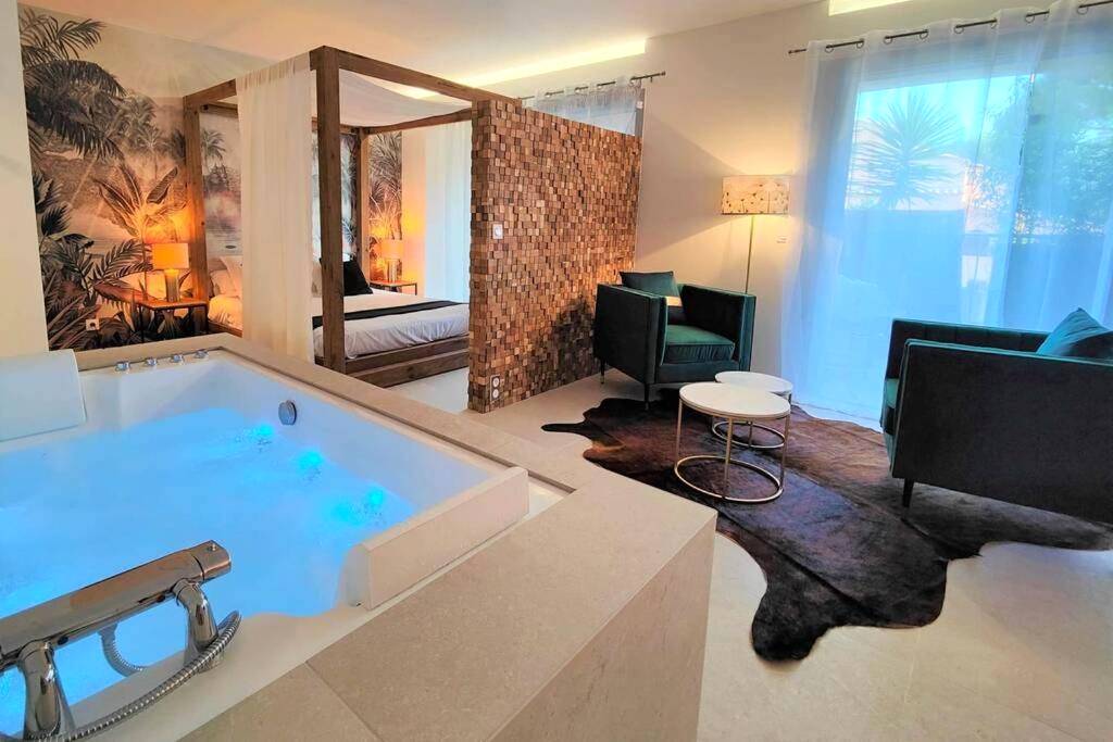 Vue d'ensemble avec jacuzzi bleu et salon - Suites JM - Le temps d'une Escale (Jacuzzi & Vue Mer)