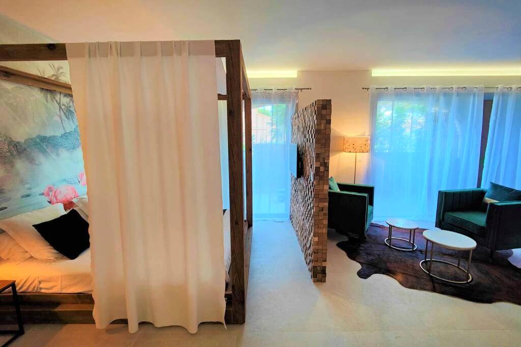 Lit à baldaquin et séparation en bois - Suites JM - Le temps d'une Escale (Jacuzzi & Vue Mer)