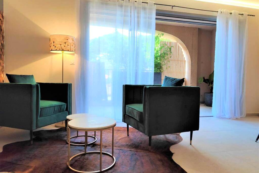 Coin salon avec fauteuils en velours vert - Suites JM - Le temps d'une Escale (Jacuzzi & Vue Mer)