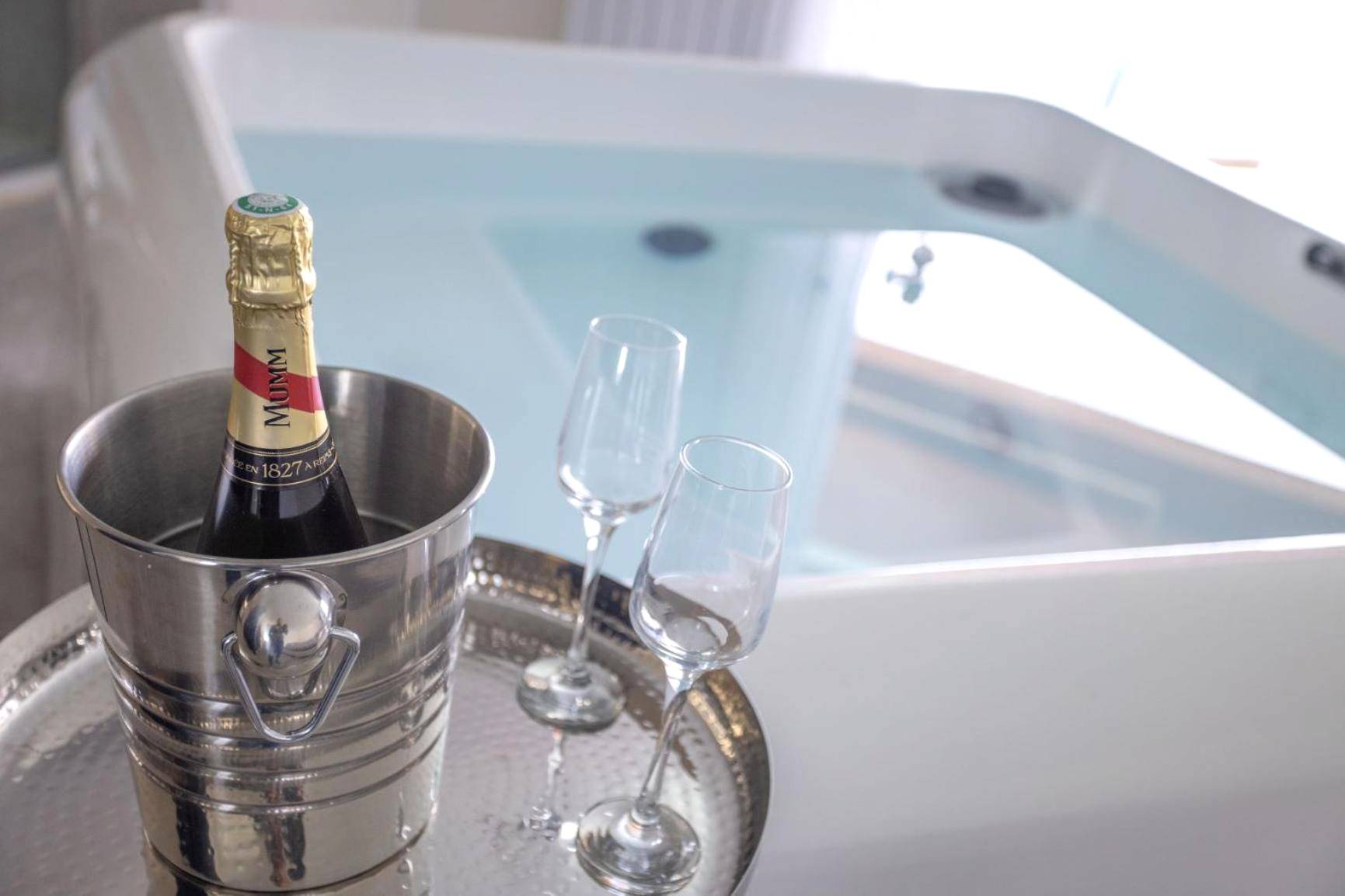Bouteille de champagne et flûtes devant le spa - LES SUITES LOVE 1 SPA VUE MER PISCINe