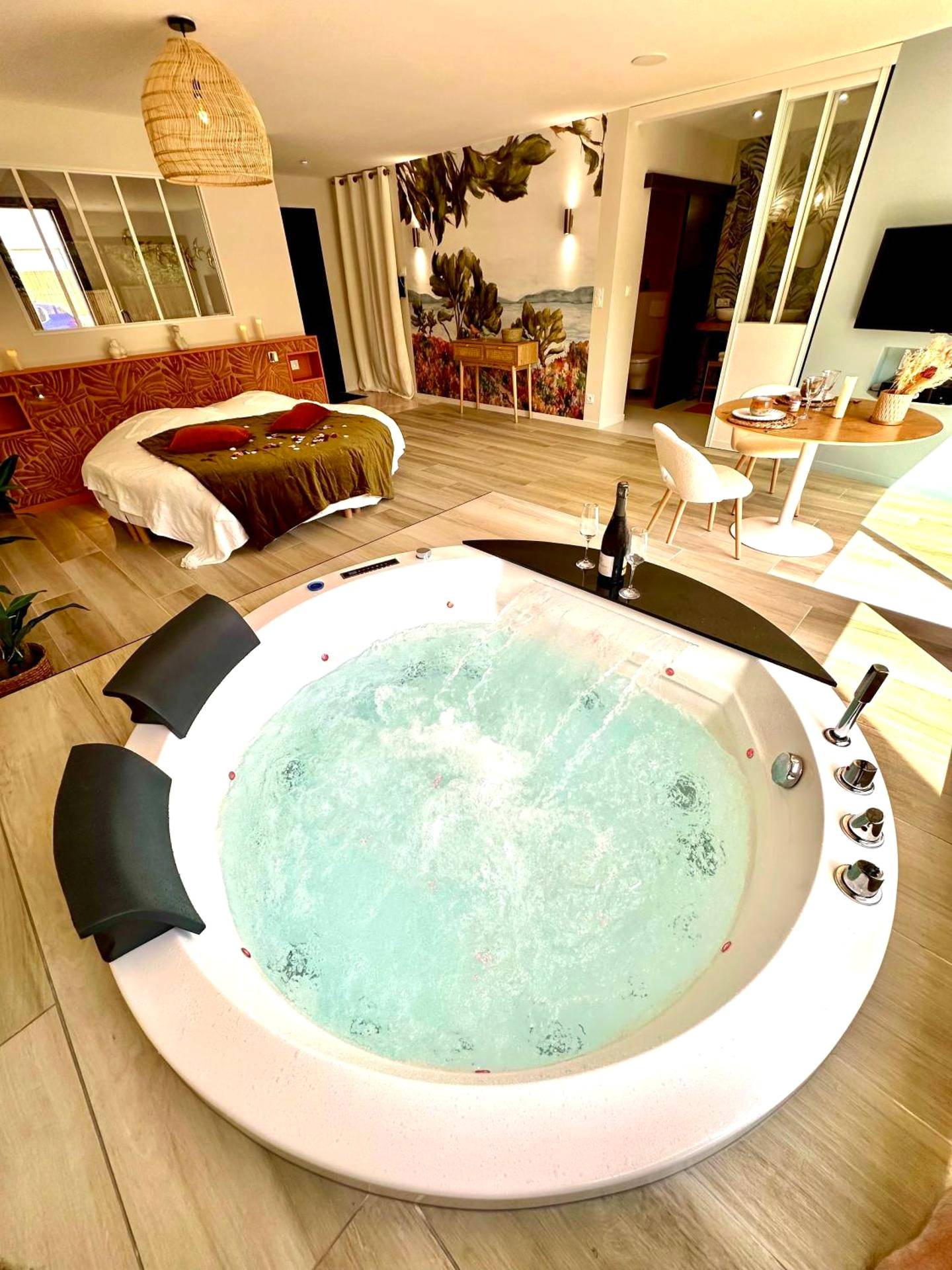 Vue d'ensemble sur jacuzzi rond et lit king size - Les Suites du Payré - Suite Romance