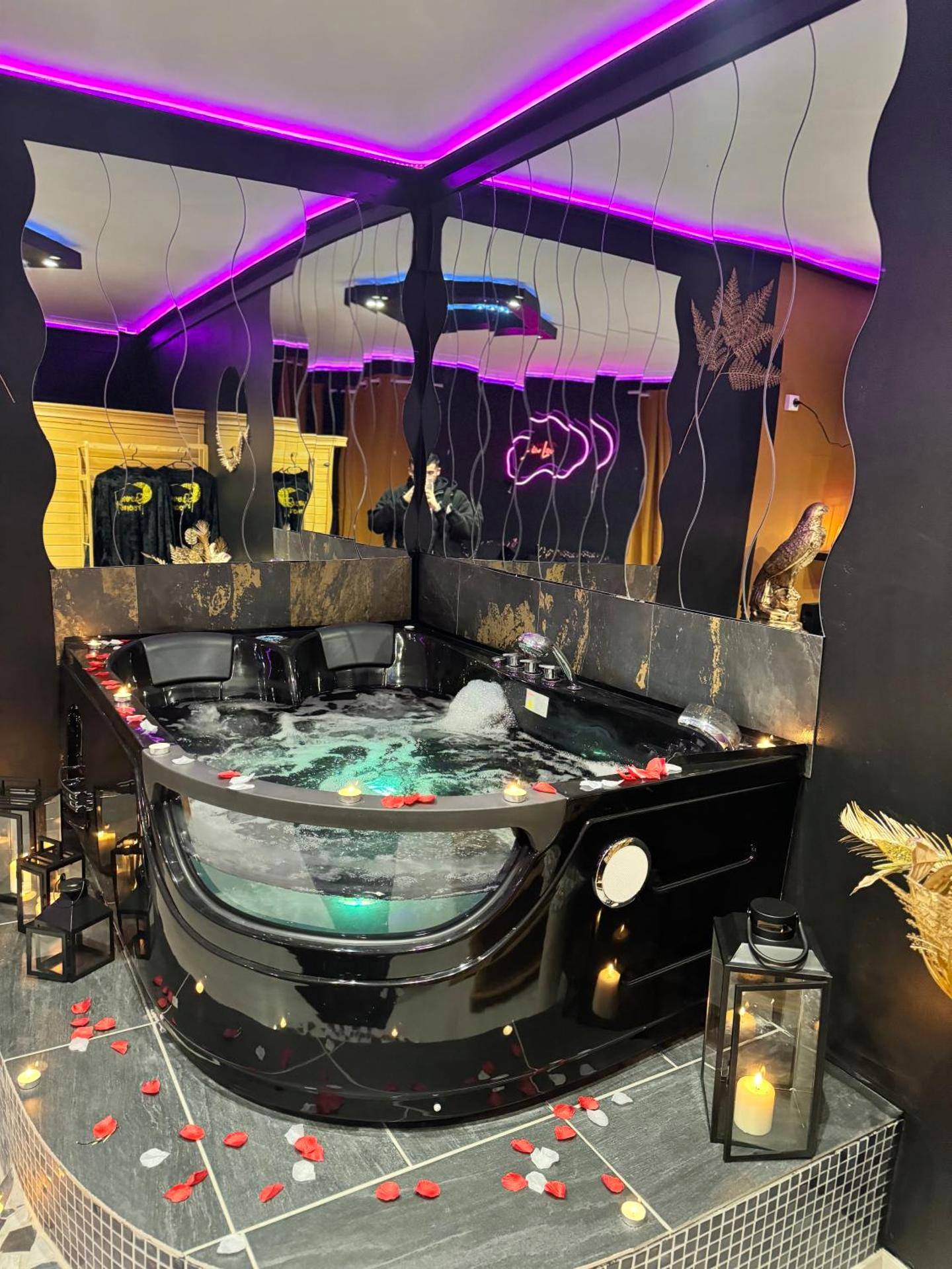 Jacuzzi noir avec pétales de rose et bougies - LA LOVEROOM by Sunnyroom