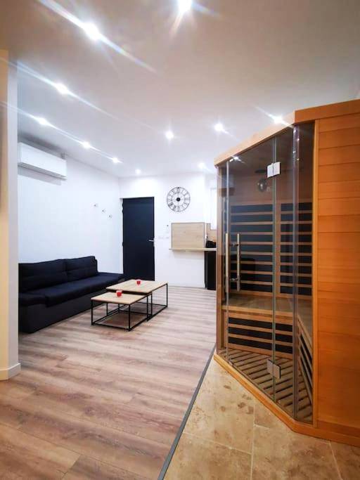 Salon moderne avec sauna en bois et canapé - Le Temple du SPA
