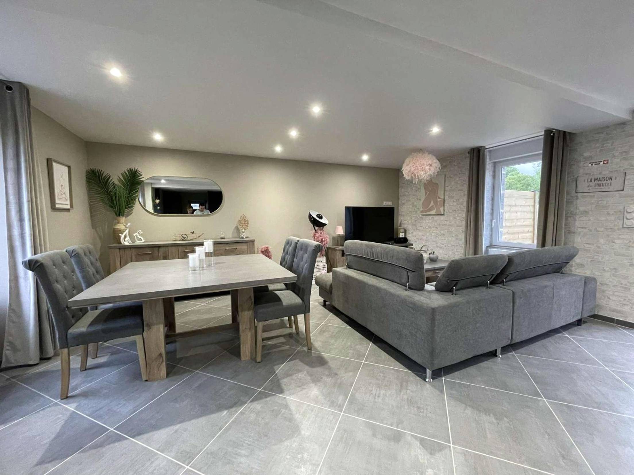 Salon ouvert avec salle à manger et canapé gris - Love Room Landisacq - Love room le temps d'un plaisir