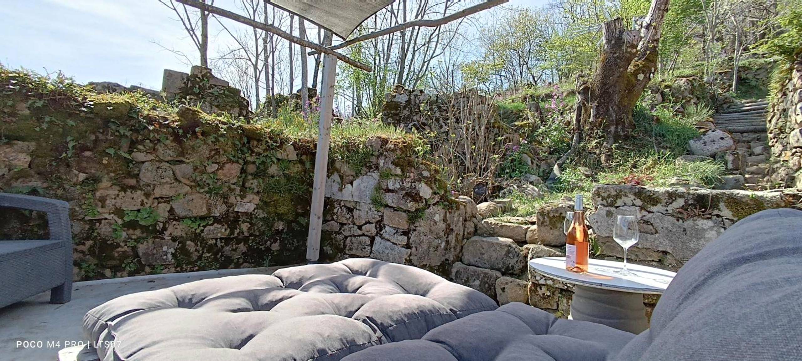 Terrasse en pierre avec banquette et vin rosé - Le Temps Suspendu