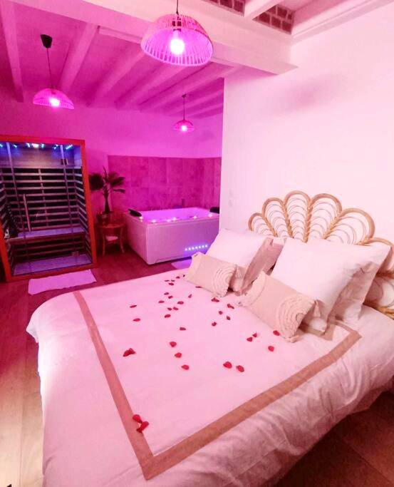 Lit avec pétales de rose et jacuzzi en fond - Love Room Gerville - Toi et moi à 8 min d etretat