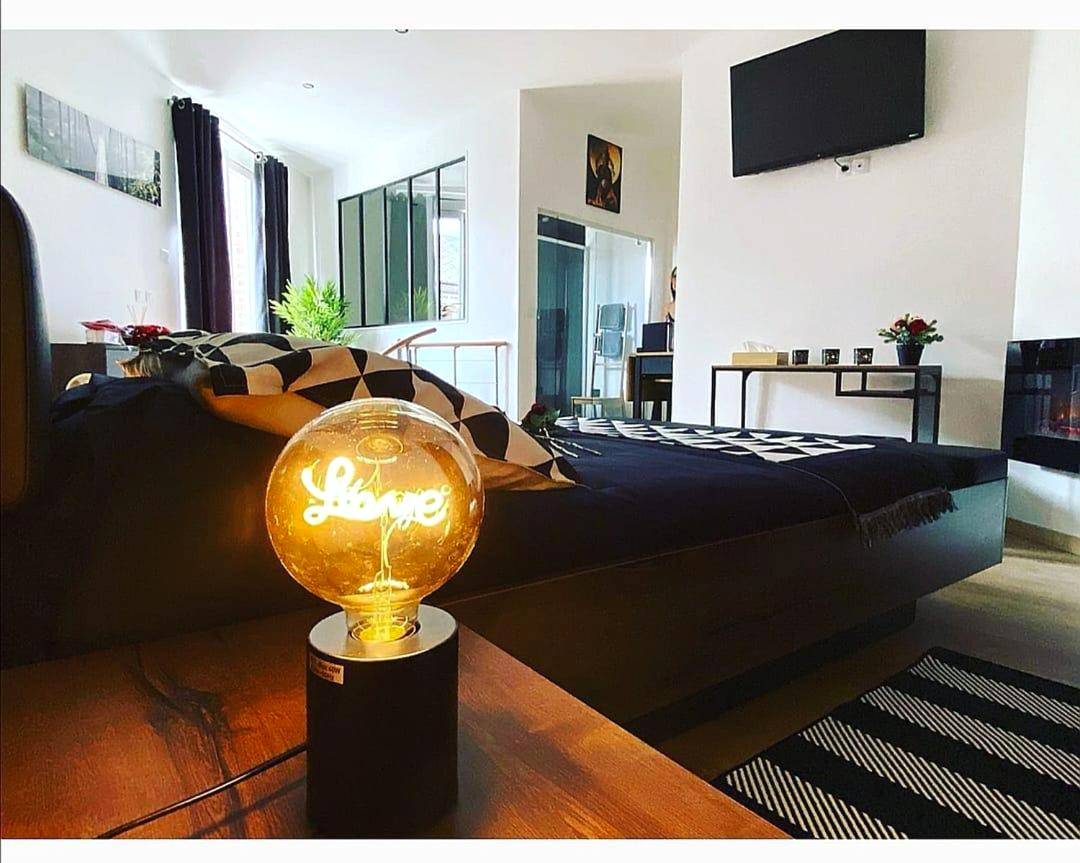 Chambre avec lampe décorative Love et TV - le tricosy jacuzzi et sauna privatif