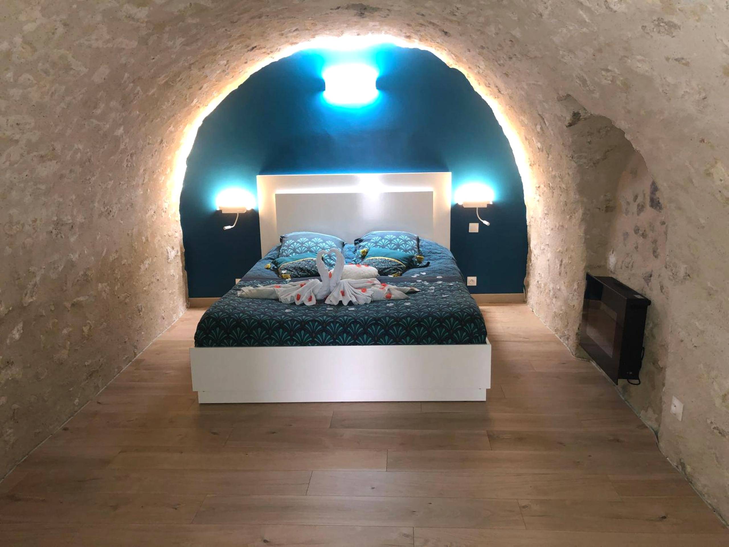Chambre voûtée en pierre avec éclairage bleu - Trog'Love: Balnéo détente dans une troglodyte