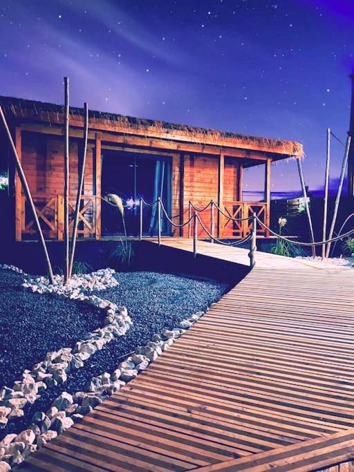 Chemin en bois menant au chalet de nuit - Tropical Spa