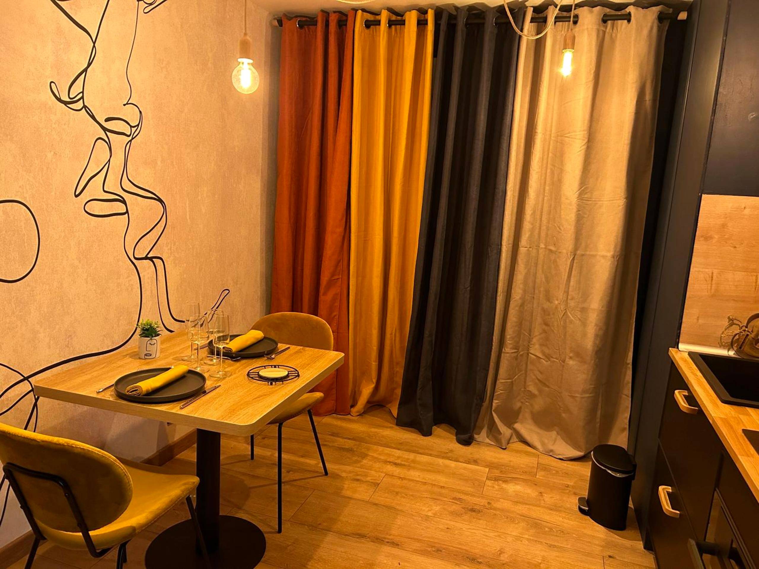 Espace repas avec table dressée et mur décoré - La Tropicale Dieppe