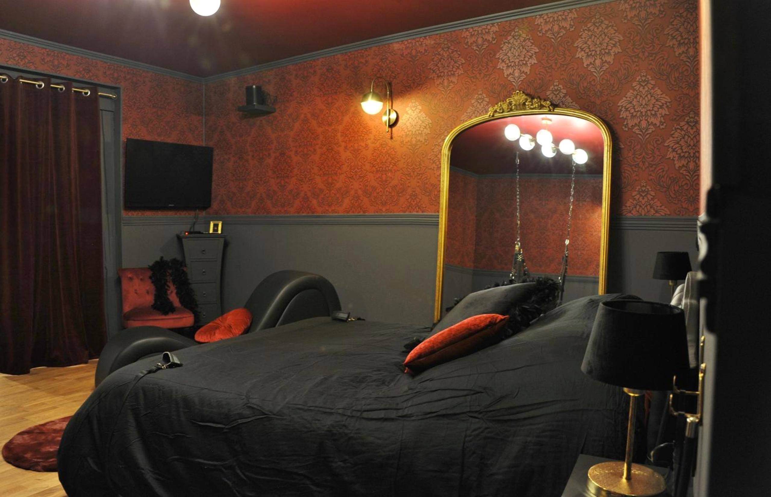 Lit double noir devant un grand miroir doré - L'Un Des Sens