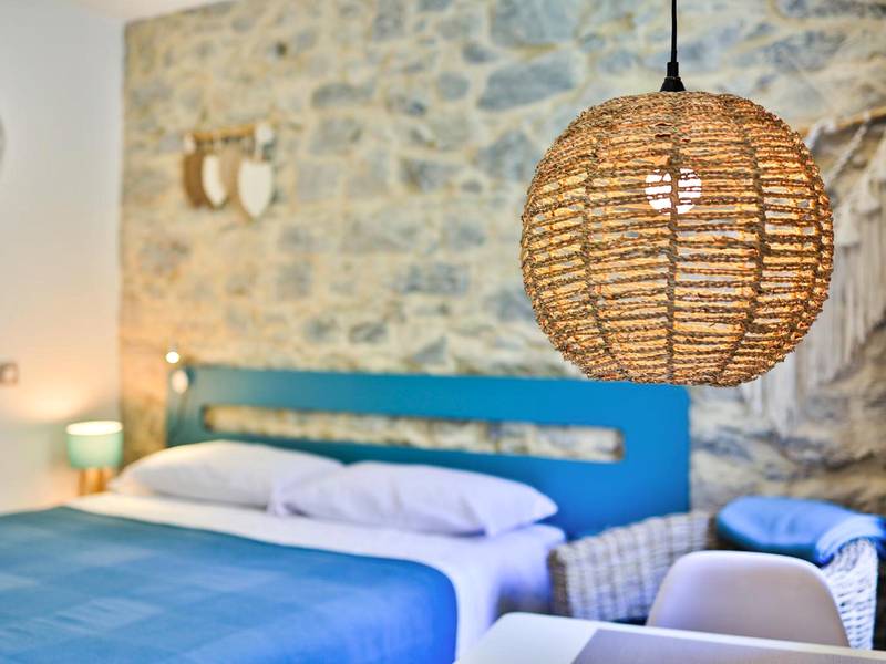 Chambre avec mur en pierre et luminaire tressé - Le Vallaya Suites & Spa