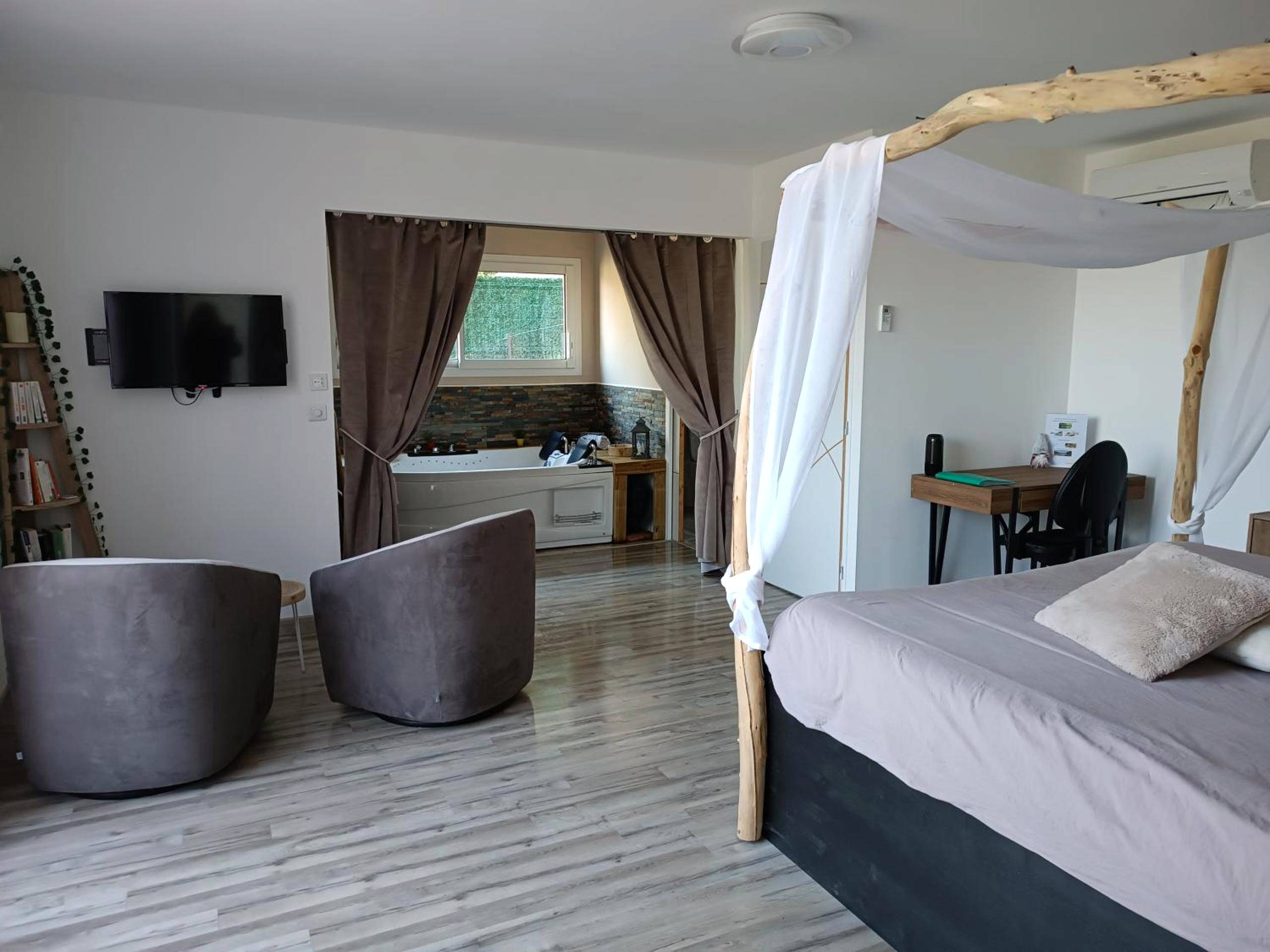 Suite avec lit à baldaquin et coin salon - séjour bien - être balnéothérapie en vallée heureuse à Sorede