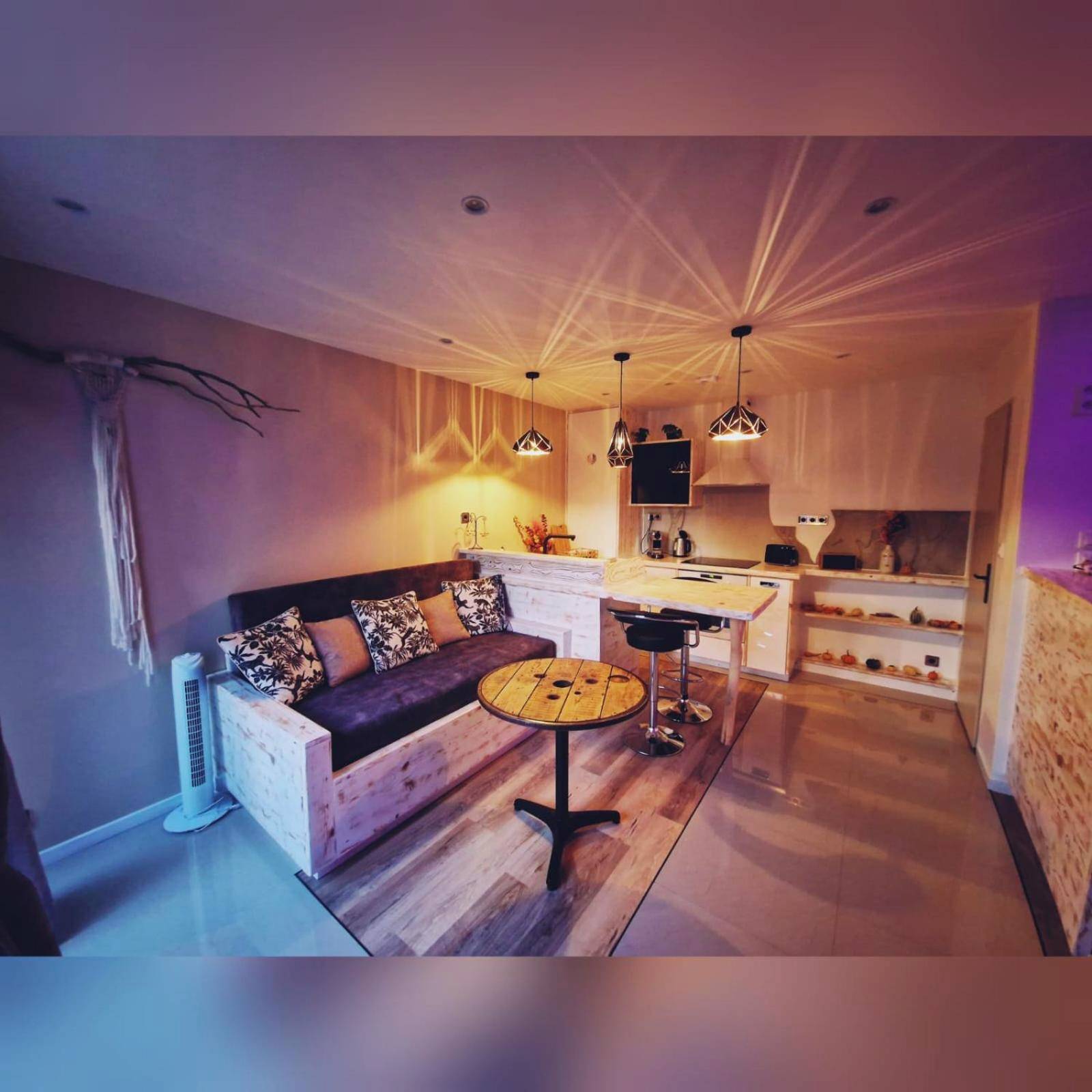 Salon avec canapé et cuisine ouverte équipée - Vanadis, Suites d'exceptions & spa - LE BALNEO