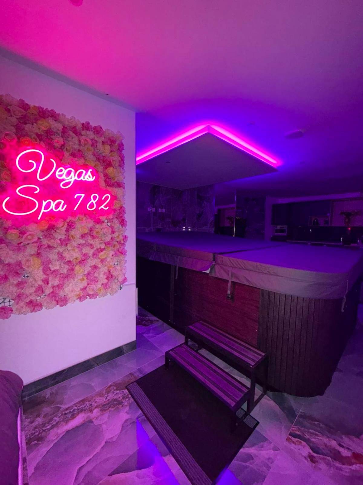 Mur de fleurs avec néon rose et spa couvert - Love Room Limay - Vegas Spa