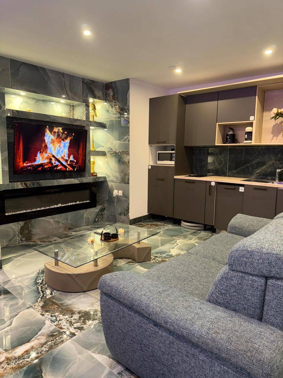 Salon avec cheminée murale et coin cuisine - Vegas Spa