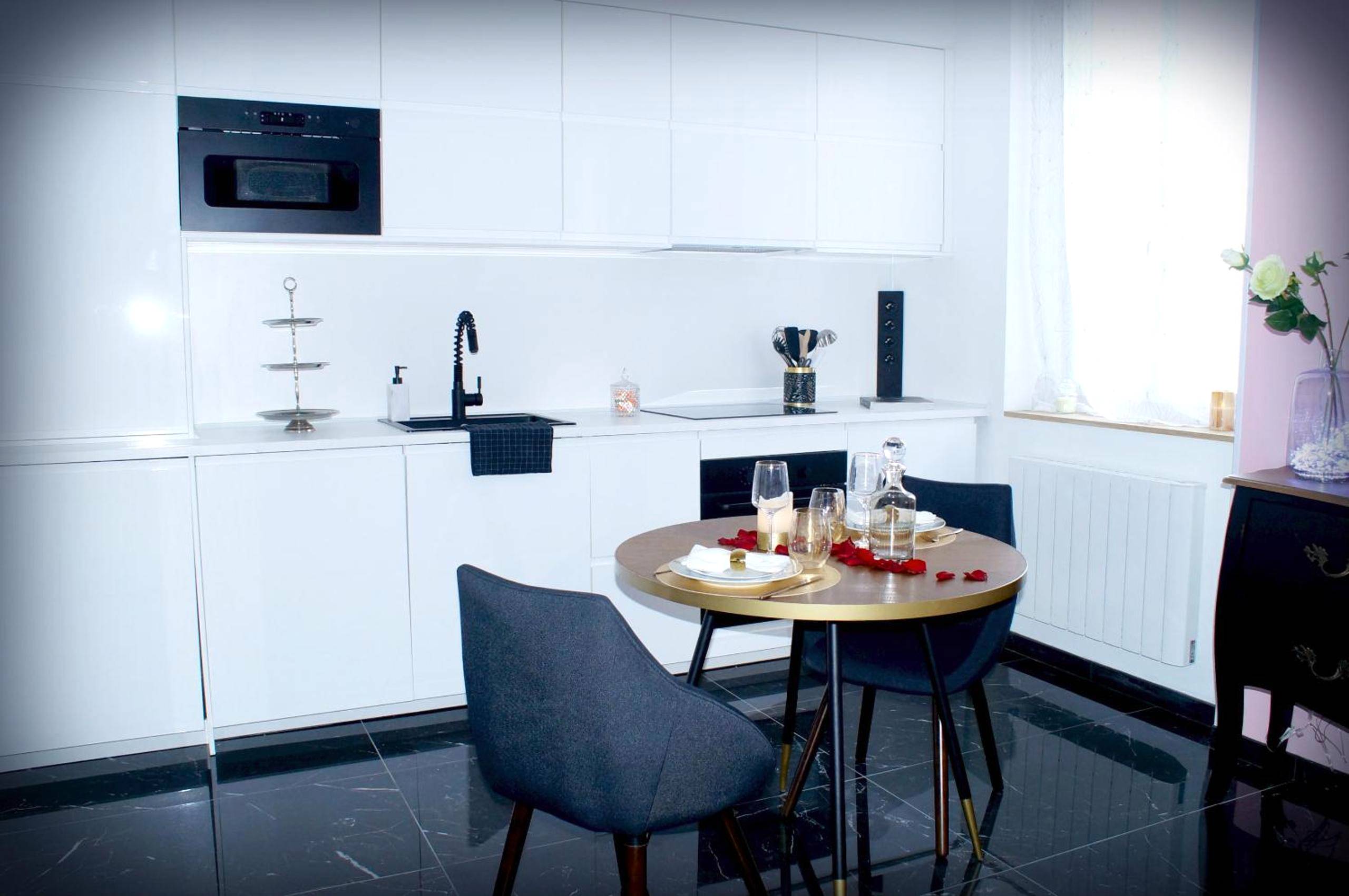 Cuisine équipée blanche et coin repas - Le Vénus - Appartement SPA Privatif Balnéo Sauna