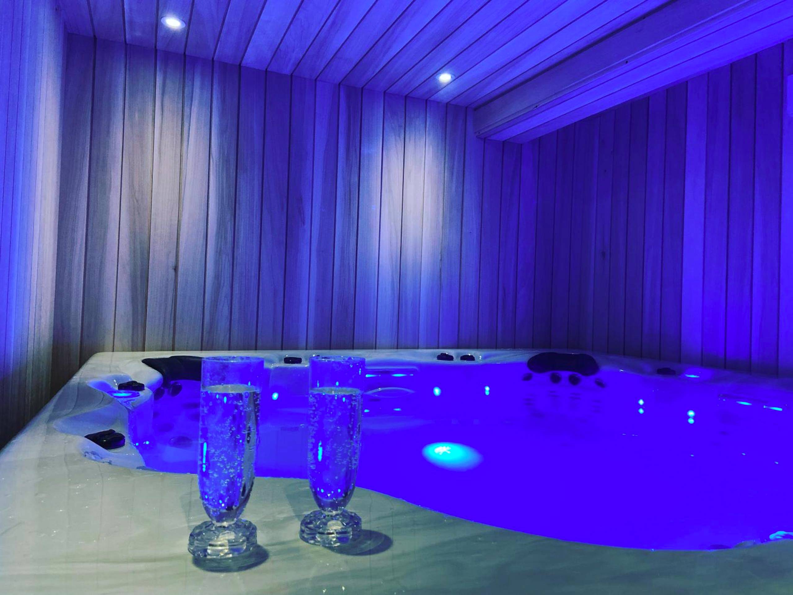 Jacuzzi privatif avec éclairage bleu néon - Love Room Niort - Vieille rose