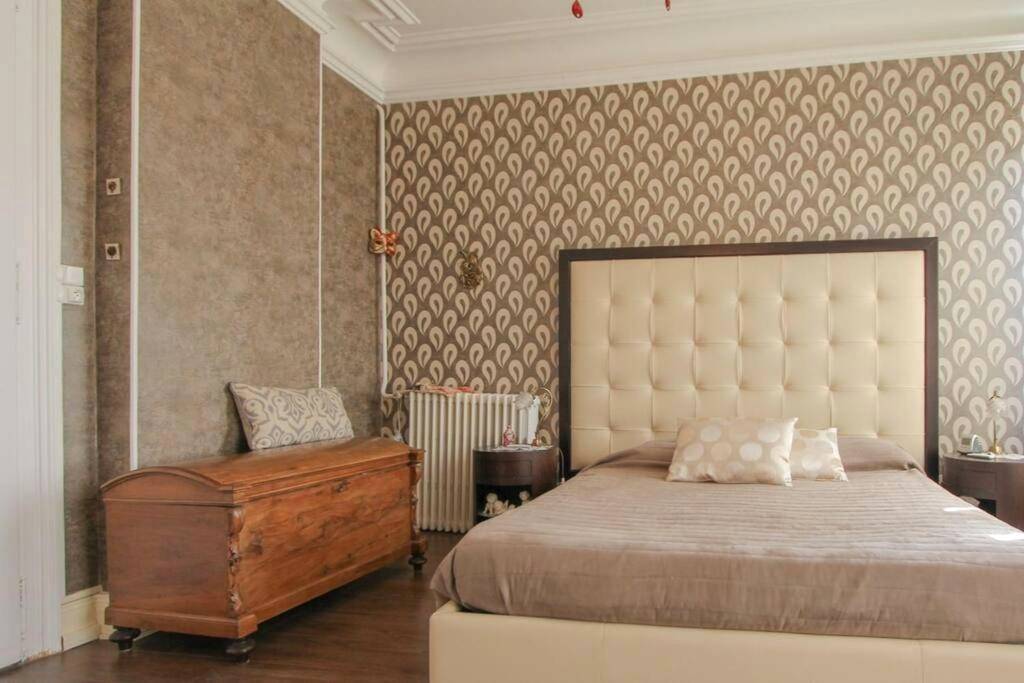 Chambre avec lit capitonné et coffre en bois - Villa Alba avec piscine et Spa