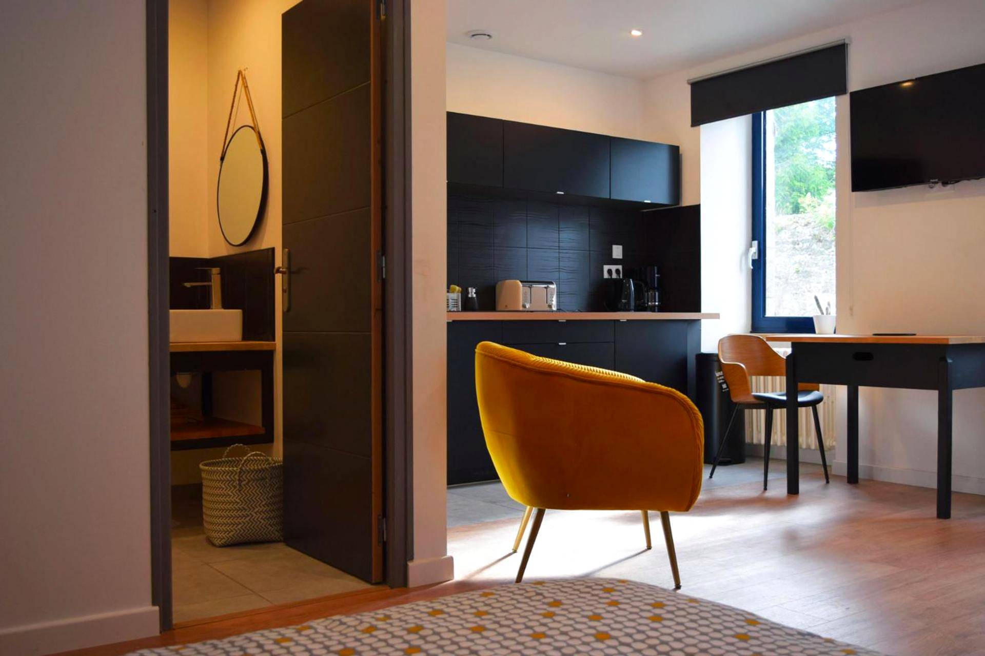 Cuisine équipée noire et fauteuil jaune - Love Room Châtelaudren - La Villa Audren Love Room Jacuzzi