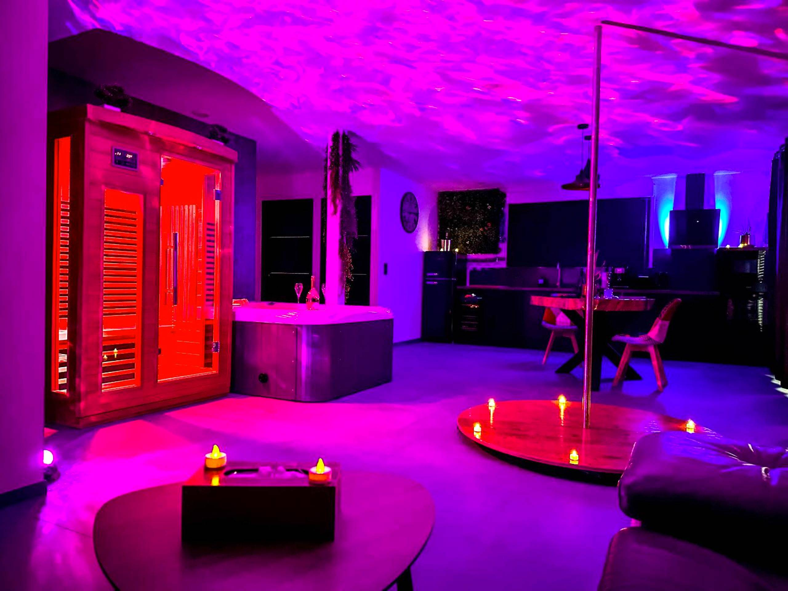 Sauna et jacuzzi sous lumière néon violette - Love Room Vias - Love room La Villa Des Charmes - 34450 vias