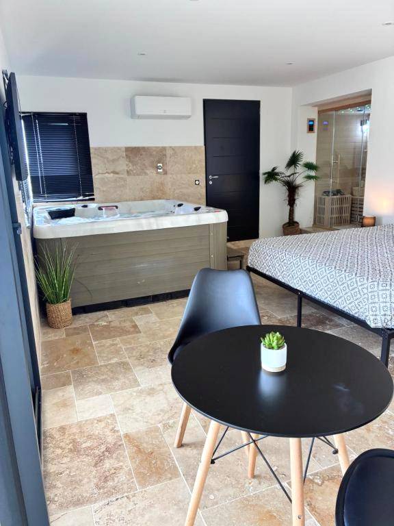 Espace détente avec jacuzzi, table et lit - Suite Privative Jacuzzi Sauna de la Villa Del Castagnol