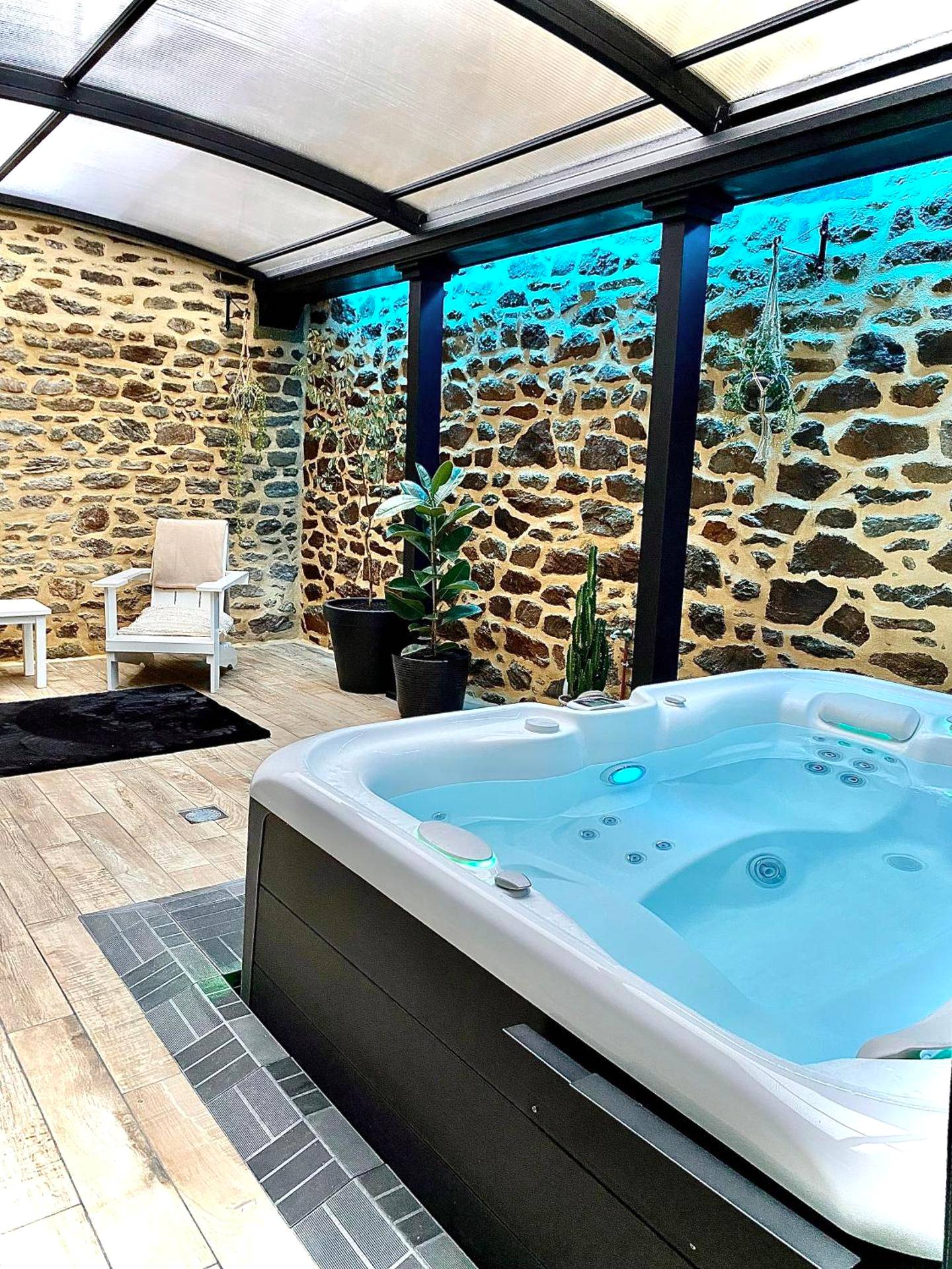 Jacuzzi privatif sous verrière et mur de pierre - Love Room La Vicomté - sur - Rance - Villa Lily Spa, chambre d’hôtes...