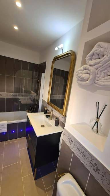 Salle de bain moderne avec miroir doré - La Villa Romane