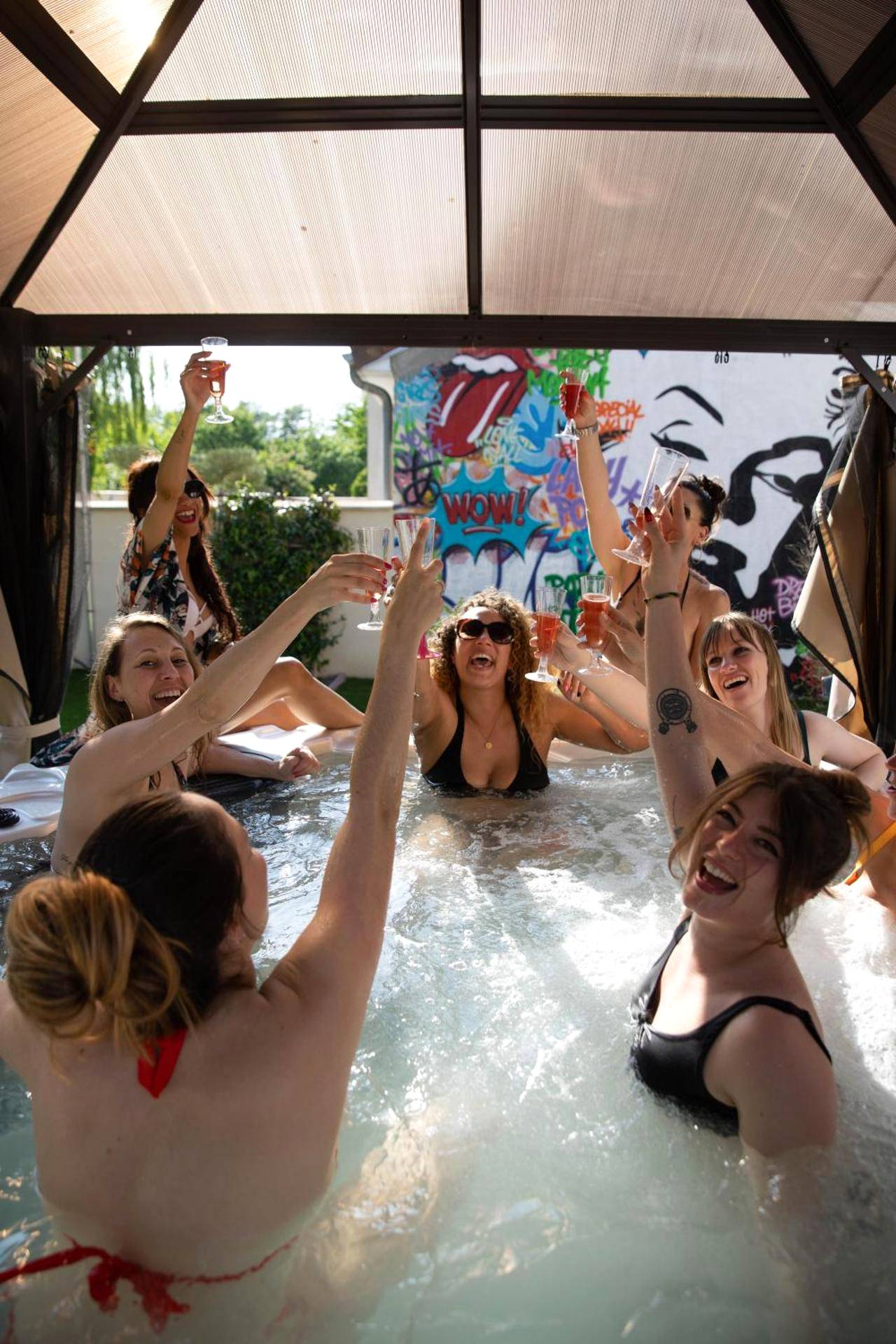 Groupe d'amis trinquant dans un jacuzzi extérieur - La Villa des Secrets