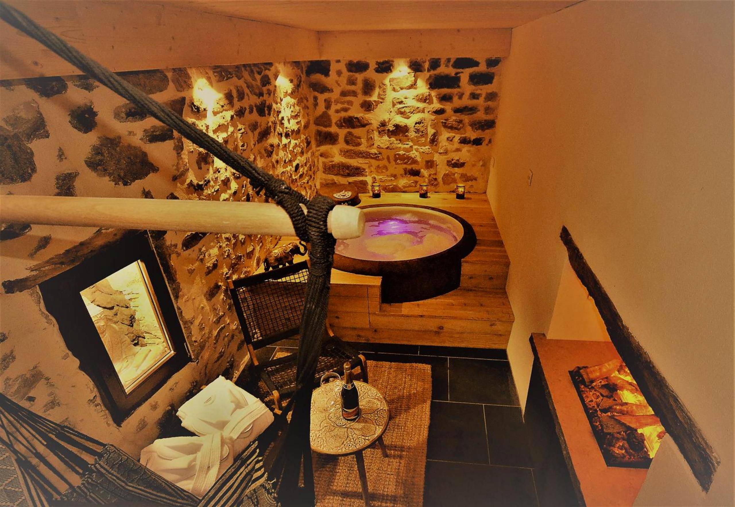 Jacuzzi rond intégré dans un podium en bois - Love Room Brindas - Au Vingtain - Appartement & Spa atypique