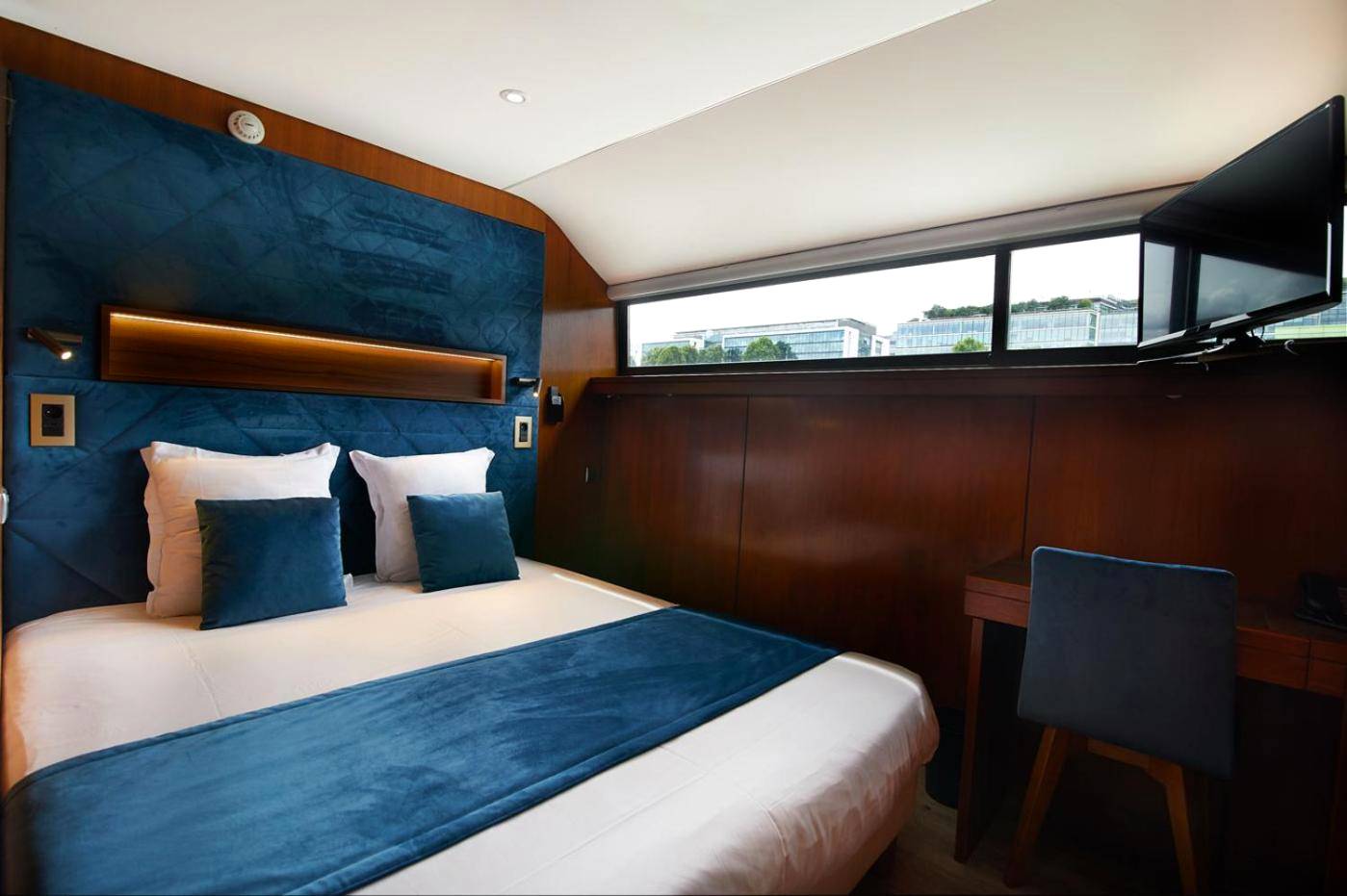 Chambre avec lit double et tête de lit bleue - VIP Paris Yacht Hôtel & Spa