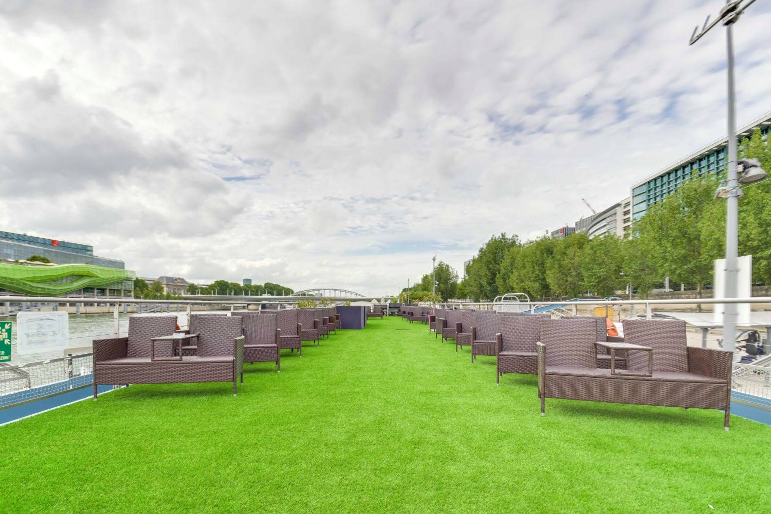 Pont terrasse avec gazon et canapés en rotin - VIP Paris Yacht Hôtel & Spa