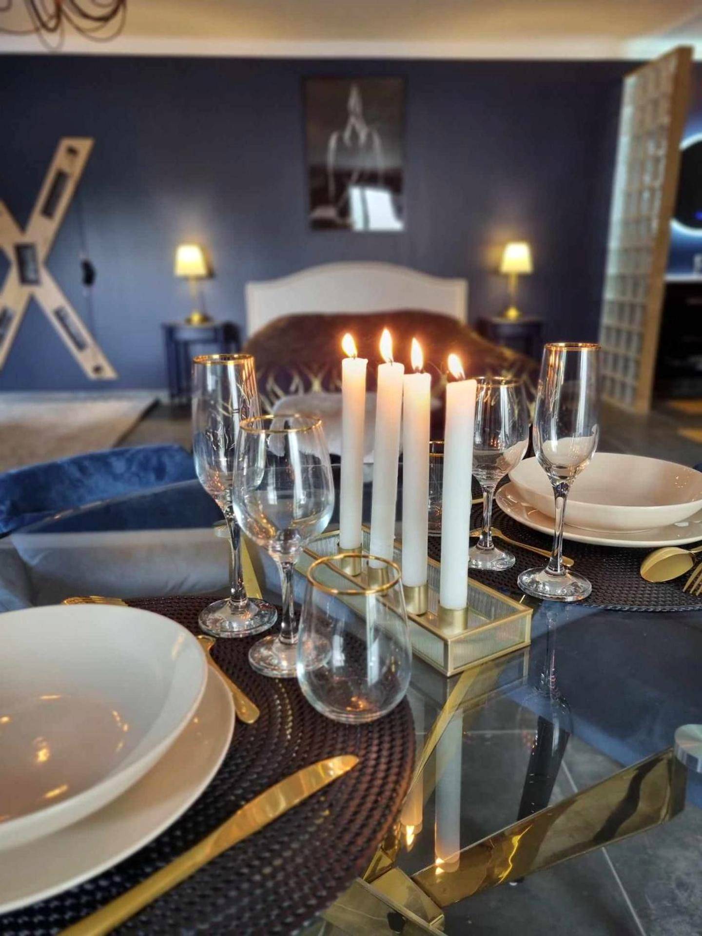 Table dressée avec bougies et verres à pied - Love Room La Volupté Spa Privatif