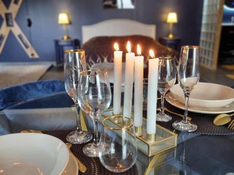 Table dressée avec bougies et verres à pied - Love Room La Volupté Spa Privatif