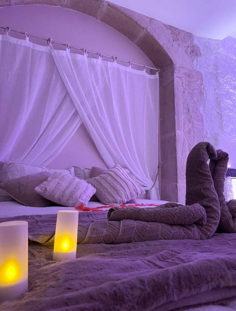 Lit romantique avec cygnes en serviette et bougies - La voute Doloise - Love room & spa