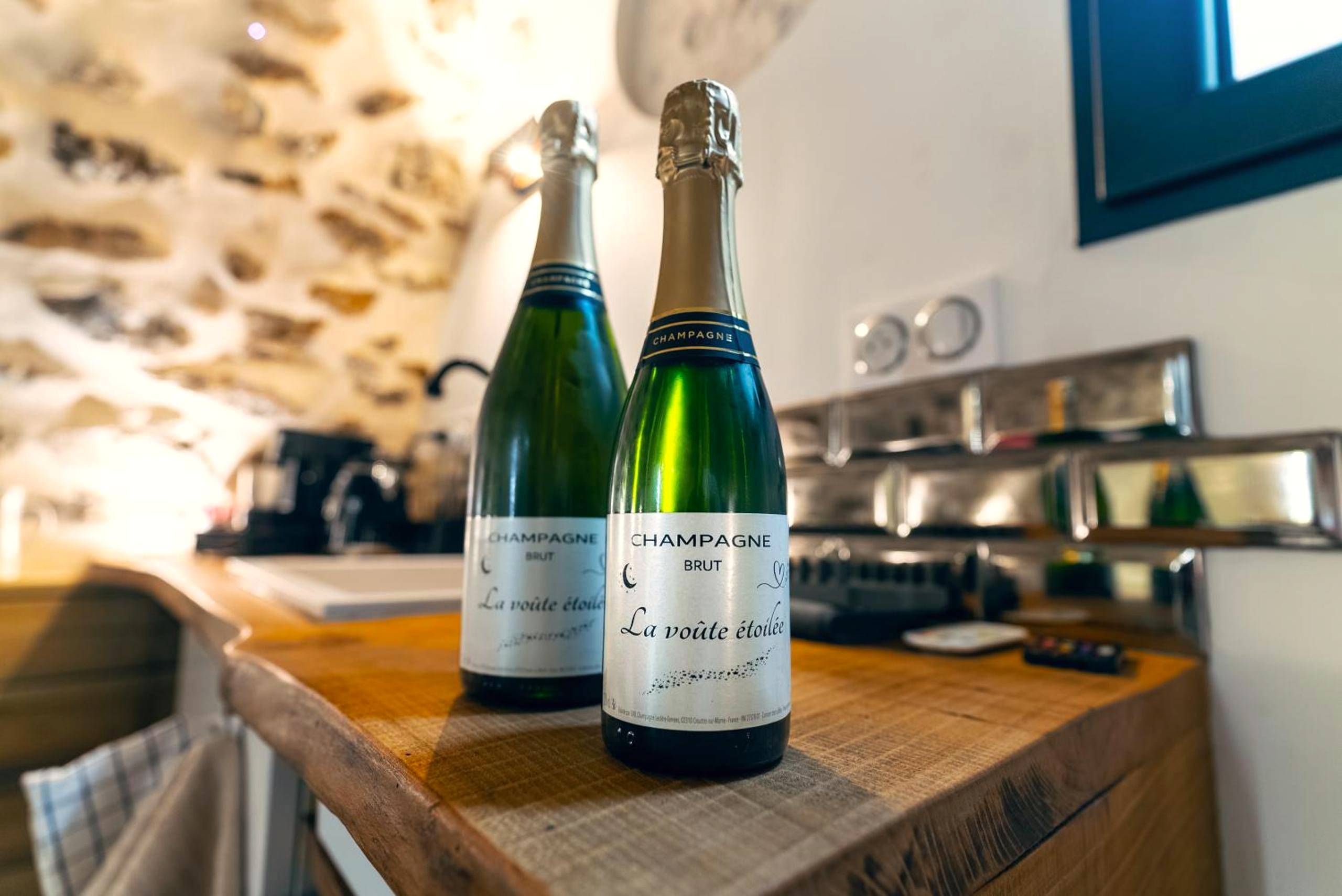 Bouteilles de champagne sur comptoir en bois - La Voûte Étoilée - Jacuzzi proche Disneyland Paris