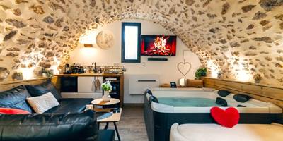 Espace détente avec canapé, jacuzzi et TV - La Voûte Étoilée - Jacuzzi proche Disneyland Paris