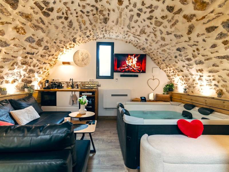 Espace détente avec canapé, jacuzzi et TV - La Voûte Étoilée - Jacuzzi proche Disneyland Paris