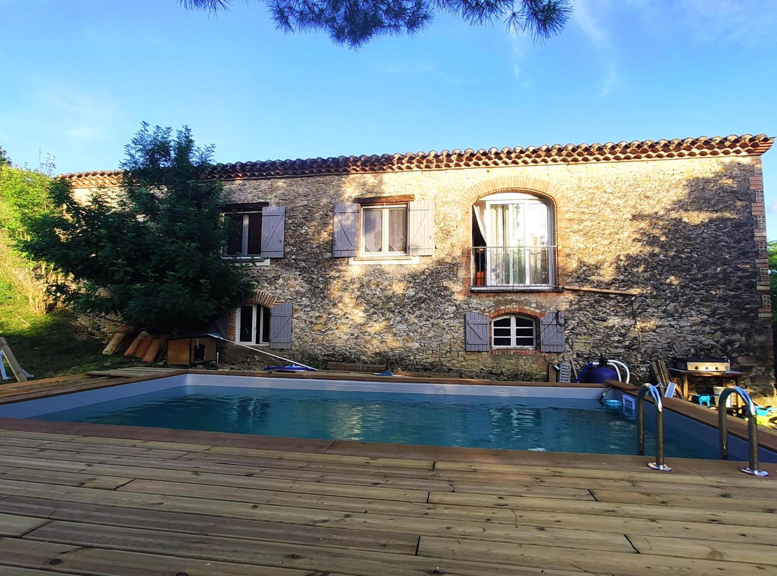 Piscine extérieure devant une bâtisse en pierre - Le Wigwam du Fassac