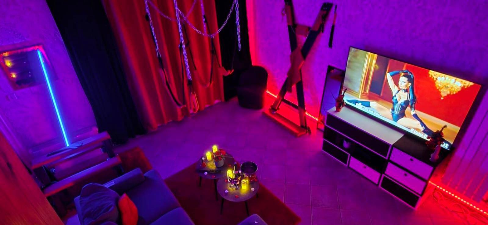 Salon thématique avec croix de Saint - André et TV - Xcoquine Love Room & Spa